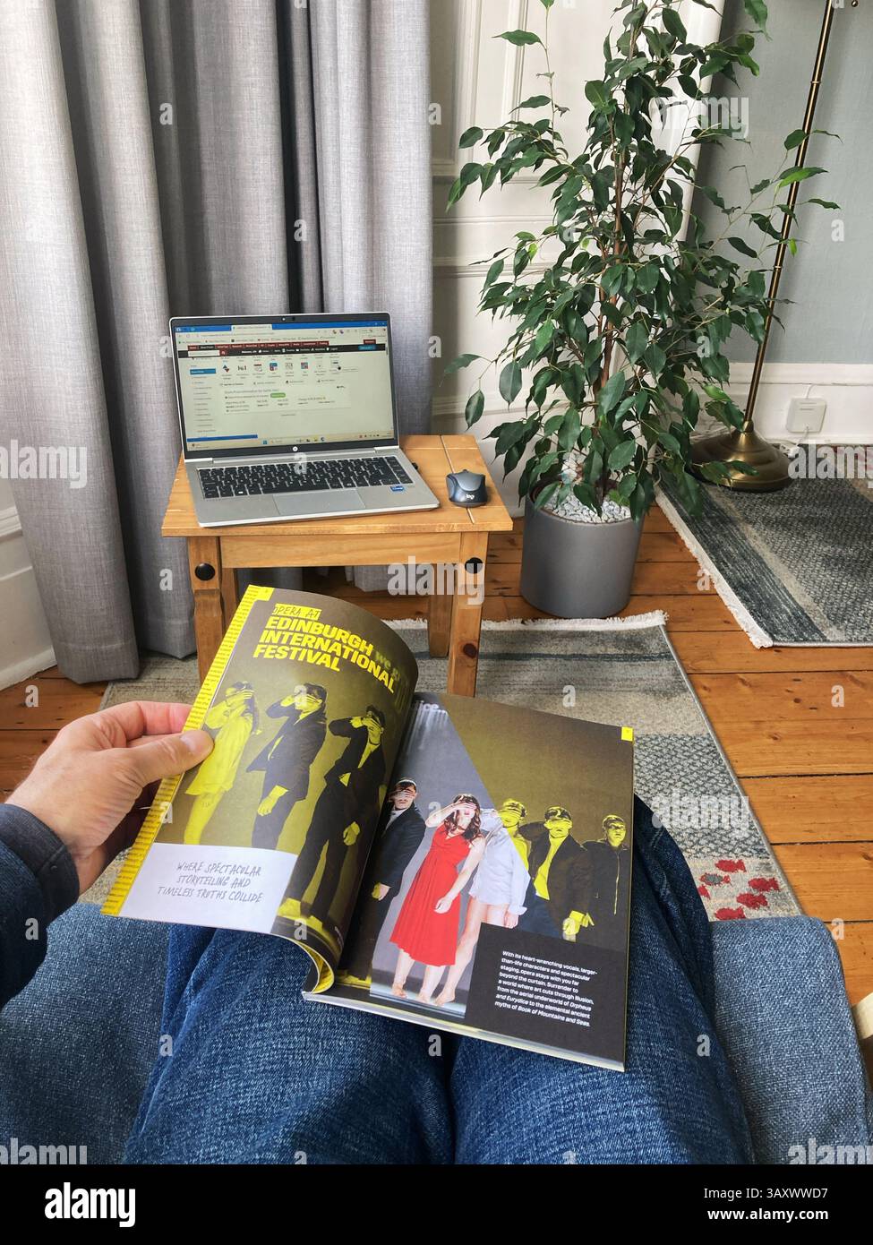 Browsing through the Edinburgh International Festival programme at home, paper copy for 2025, the festival dates are 1st–24th August 2025 - Smartphone Captured Stock Image