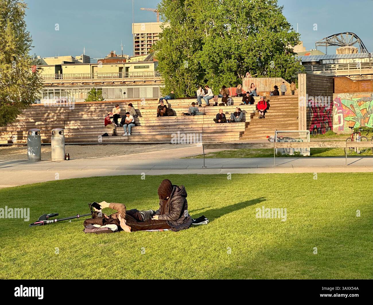 People relaxing in the Park am Gleisdreieck in Berlin on a sunny spring evening - Smartphone Captured Stock Image
