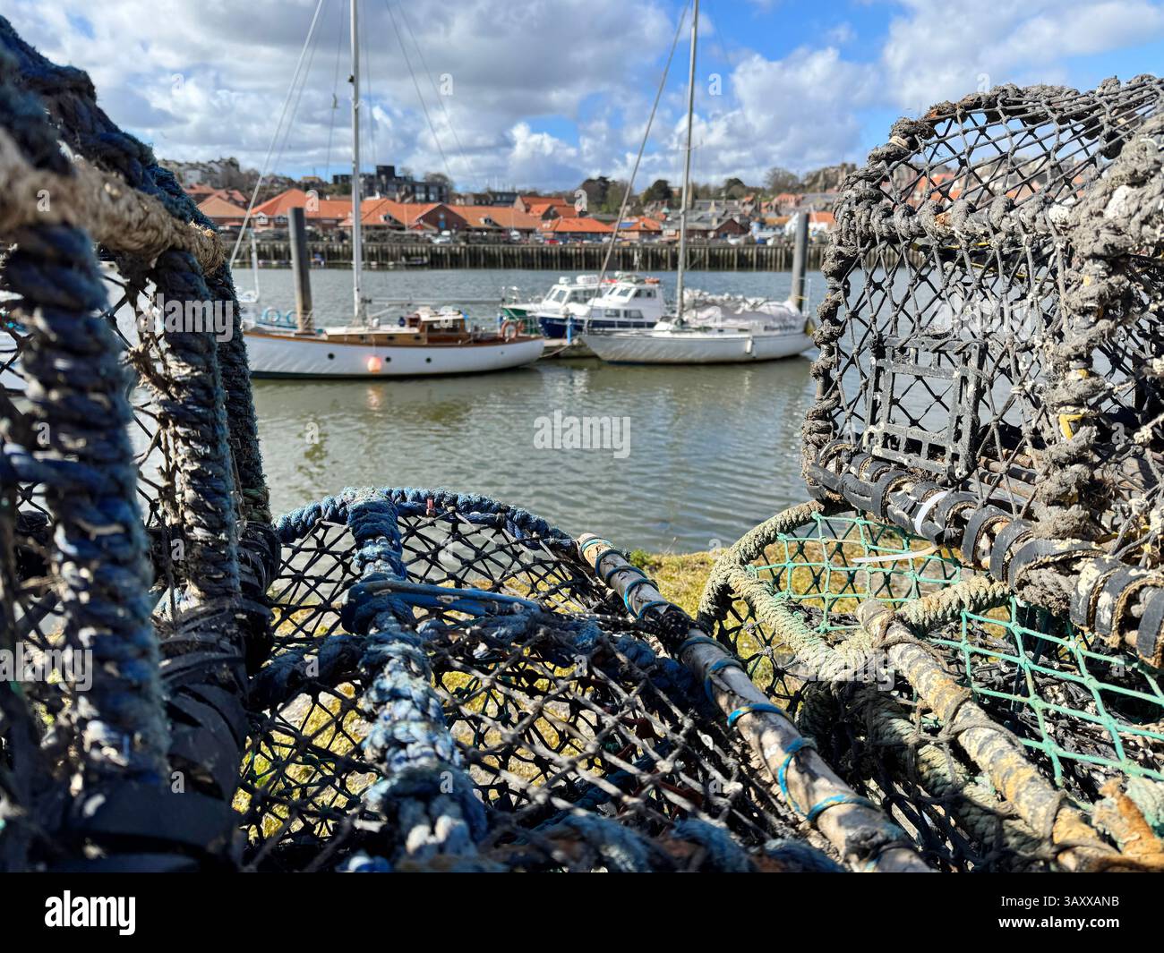 Fishing industry in Whitby lobster pots and ropes on Church Street looking onto the River Esk Stock Photo