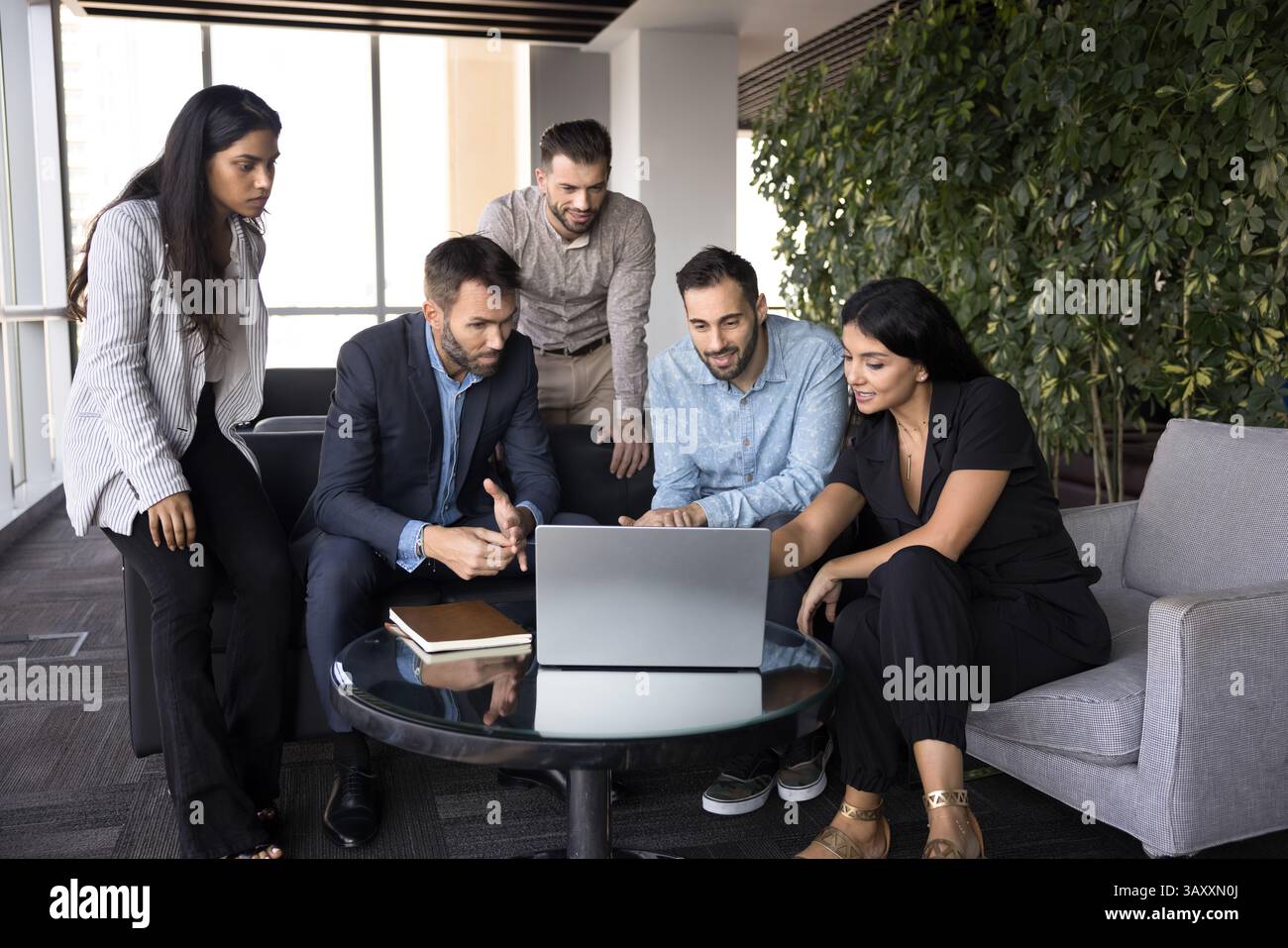 Workflow using modern technology of five diverse employees Stock Photo