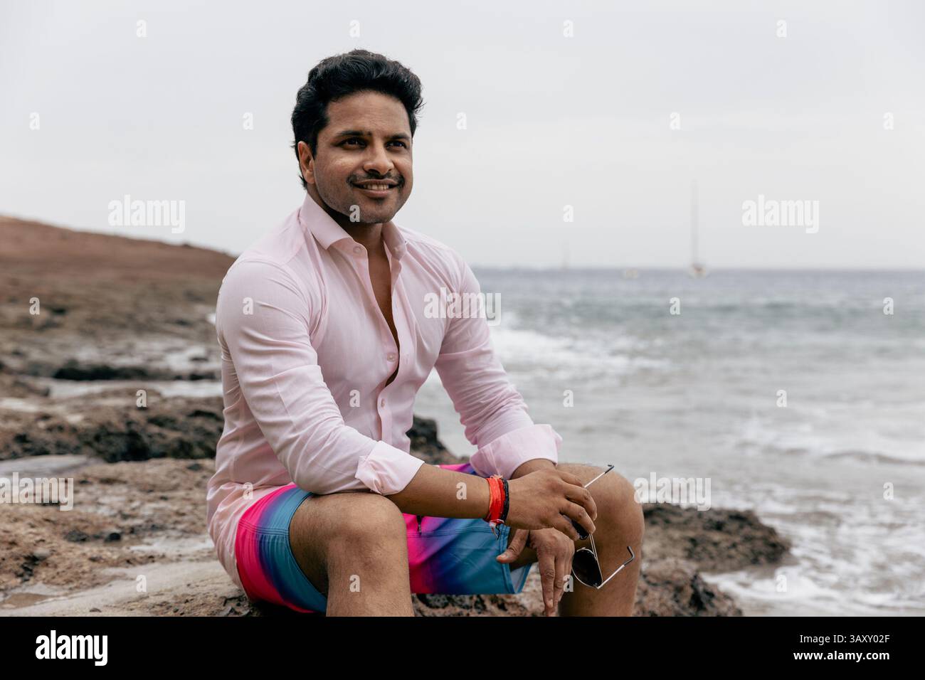 A confident man at the beach relaxing during his summer holiday Stock Photo