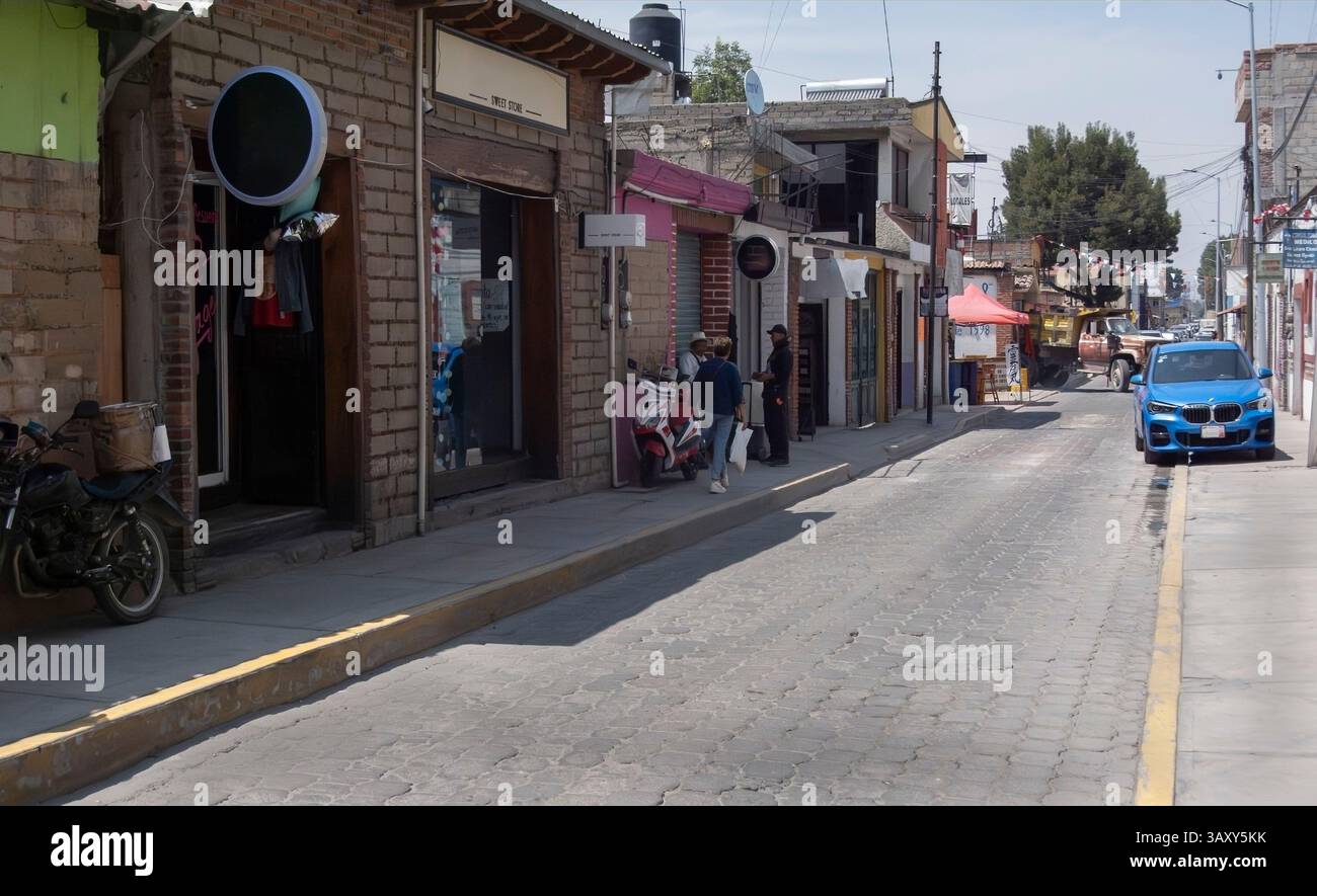 Harsh mid-day sun illuminates a gritty Mexican city street Stock Photo