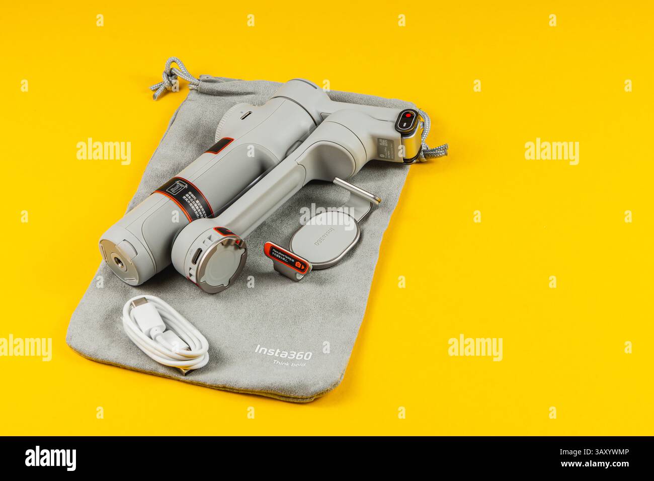 Lviv Ukraine 07.04.25 A handheld camera stabilizer and essential accessories are showcased on a bright yellow background, highlighting its compact des Stock Photo
