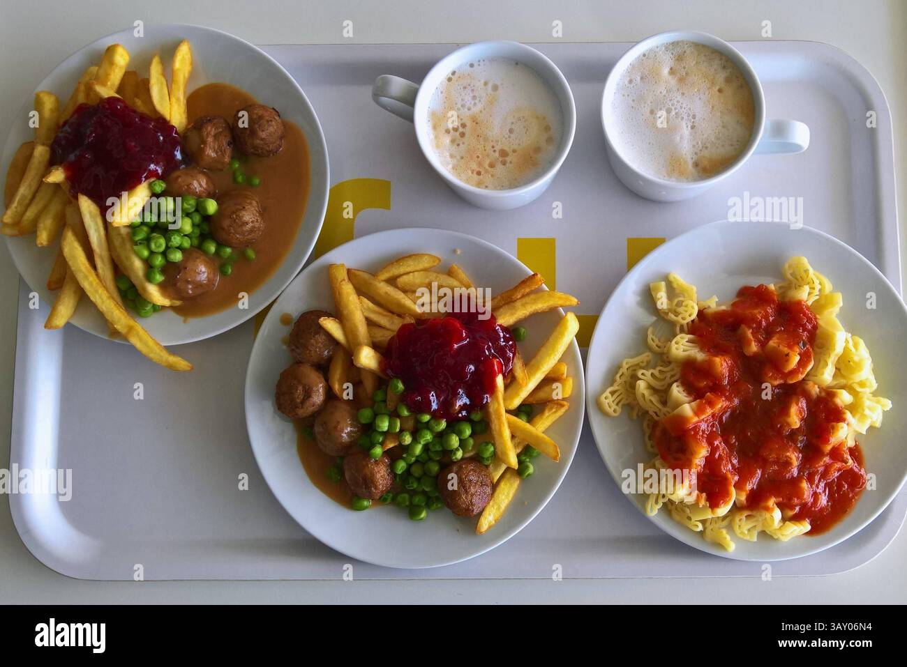 Ikea Restaurant, Mittagessen auf einem Tablett. Zwei Tassen mit Cappuccino, Köttbullar mit Pommes, sowie Rispanna
