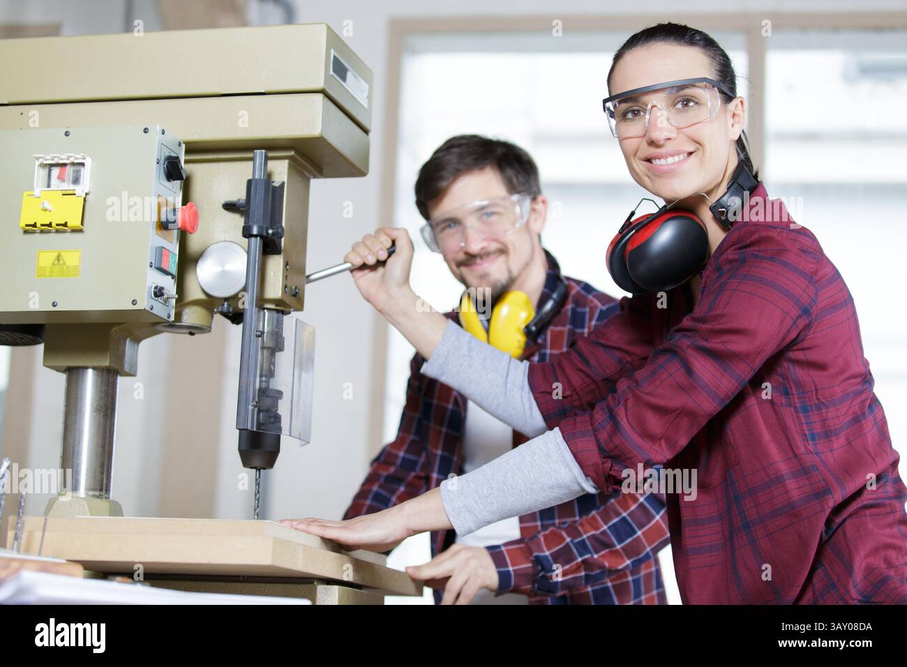 engineer training female apprentice to use cnc machine in factory Stock Photo