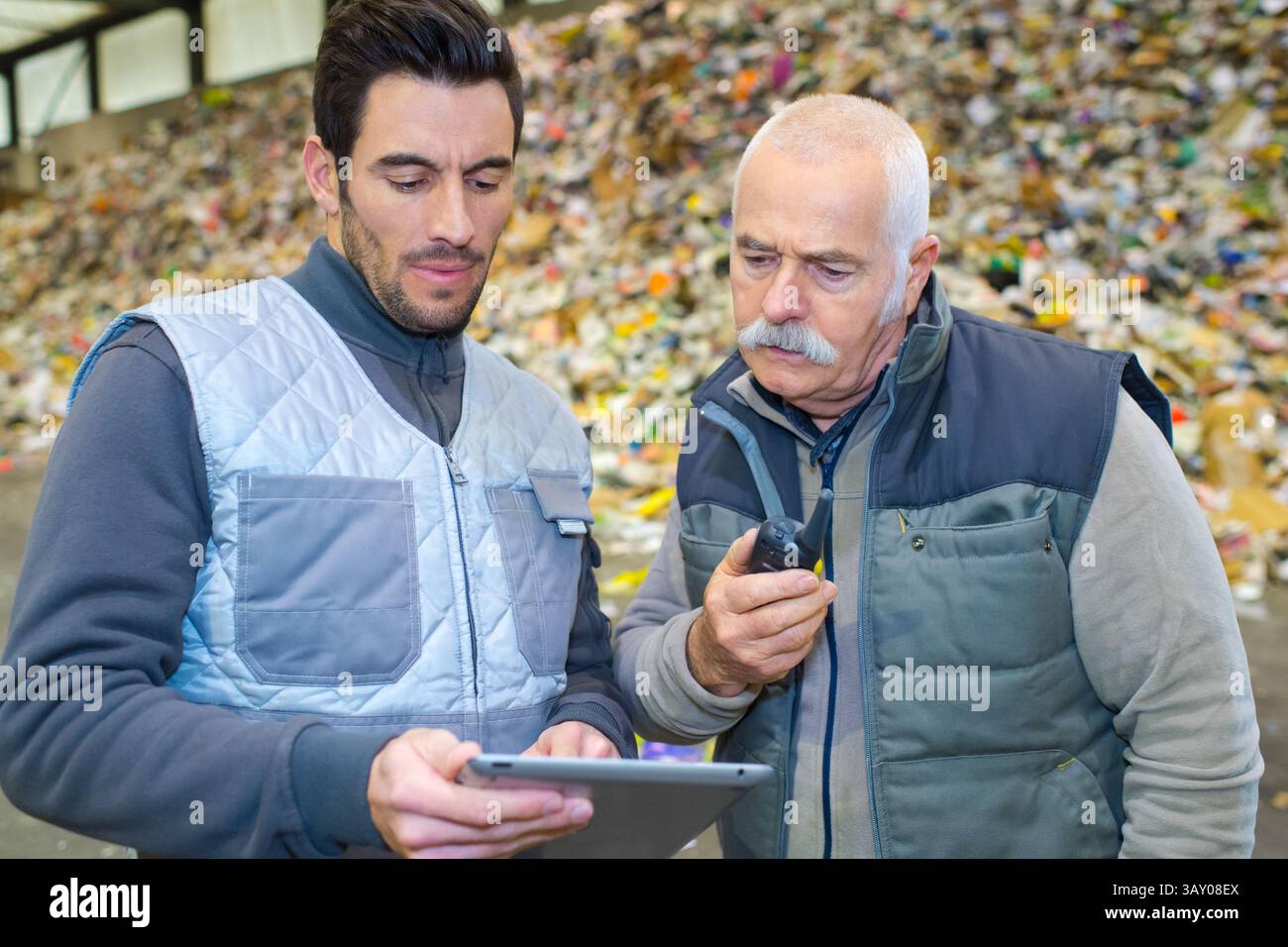 workers looking at digital tablet in recycling center Stock Photo