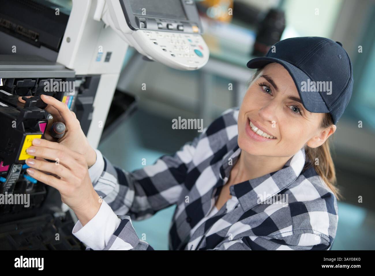 a happy woman fixing the printer Stock Photo
