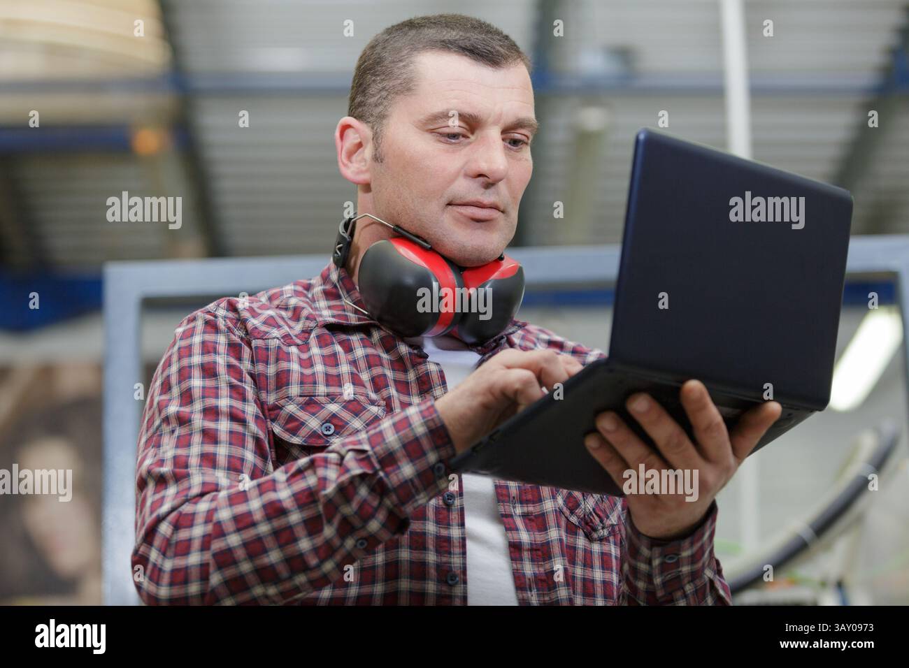 construction worker using laptop at bulding site Stock Photo