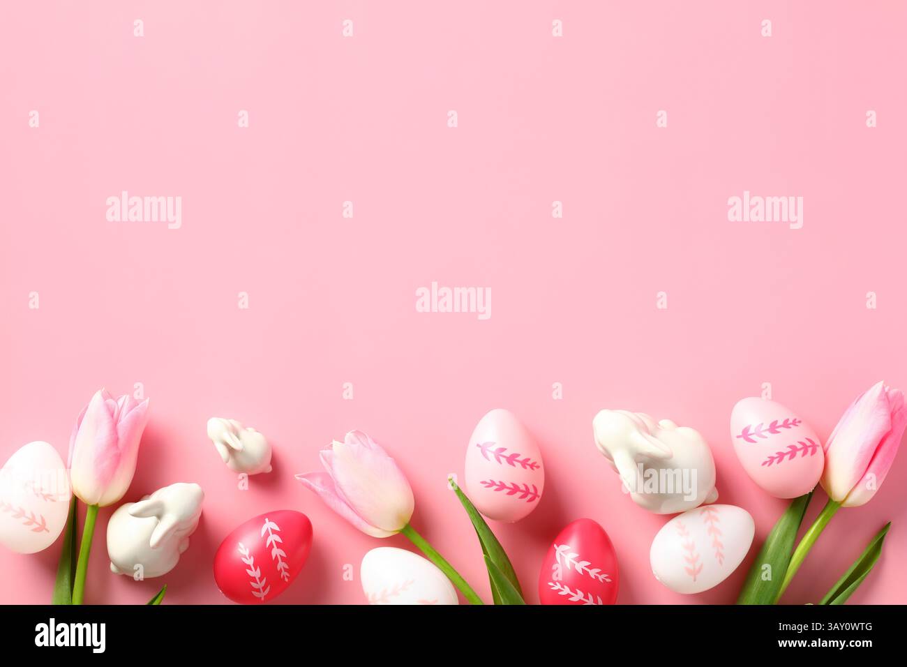 Happy Easter concept. Easter card with colorful eggs, decorative bunnies and tulips on a pink background. Stock Photo
