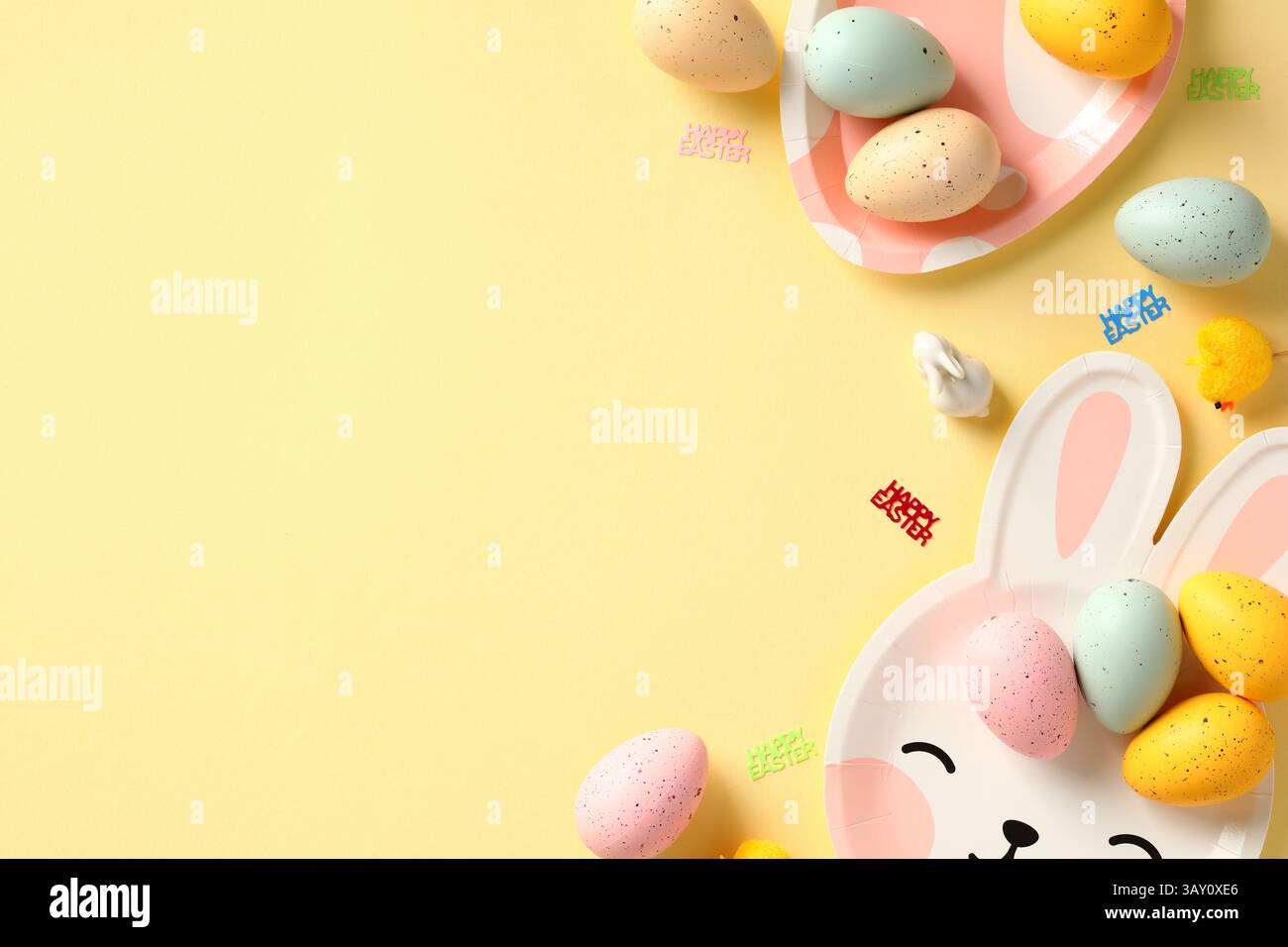 Happy Easter banner design with colorful Easter eggs and tableware on yellow background Stock Photo