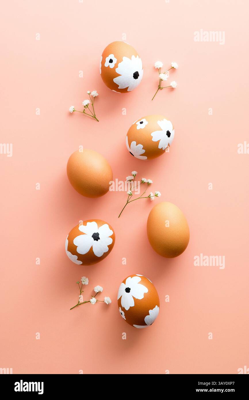 Happy Easter creative flat lay composition. Easter eggs and flowers on pastel pink background. Stock Photo