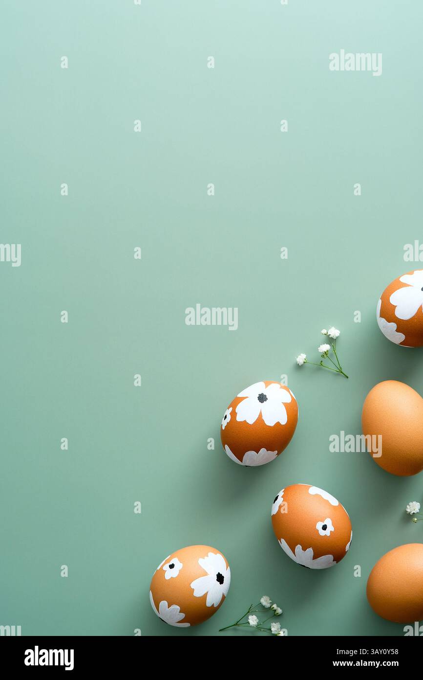 Elegant Easter flat lay composition. Easter painted eggs and flowers on pastel green background. Flat lay, top view. Happy Easter vertical banner temp Stock Photo