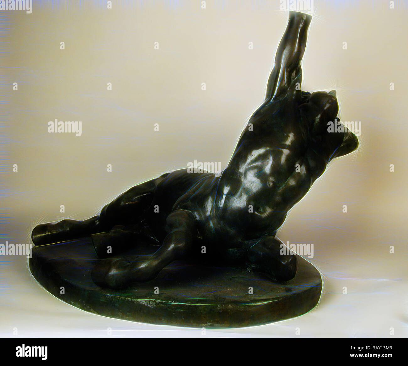 A powerful sculpture depicting a muscular lion in a dynamic pose ...