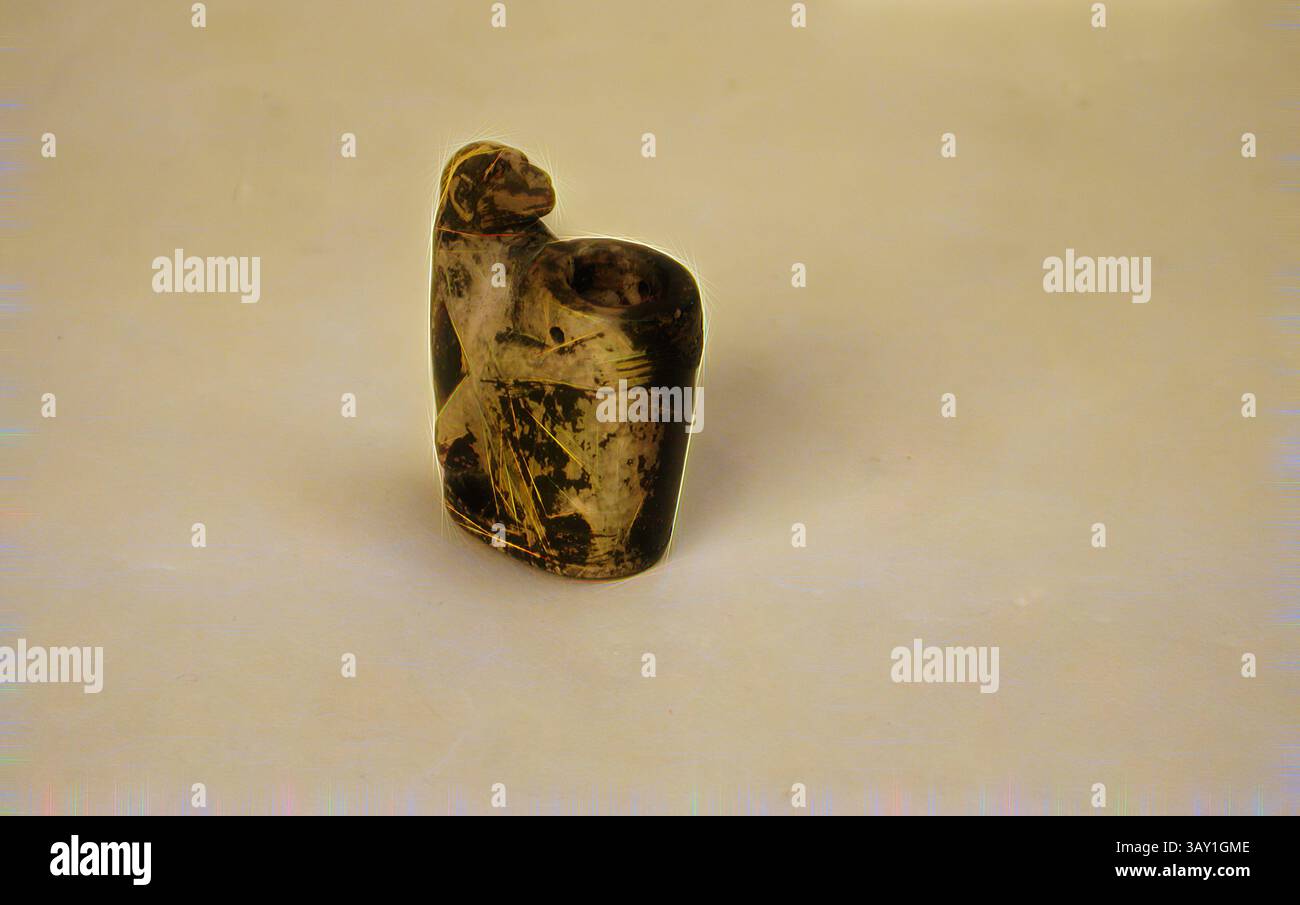 This artifact depicts a seated figure, possibly representing a deity or ...