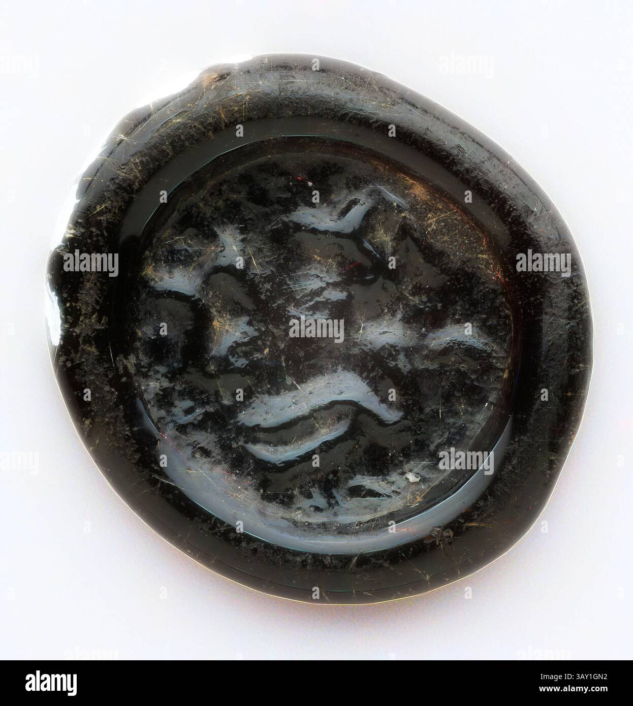 An ornate seal featuring a carved design that depicts a stylized face, surrounded by smooth, reflective edges. The intricate details highlight the craftsmanship involved in its creation, suggesting historical significance or artistic purpose., Islamic, Egyptian, Quarter Dirham Coin Weight from the Reign of the Fatimid Caliph al-Mustansir, 1036/1094, Glass, 1/16 x 9/16 in. diam. ( .15 x 1.42 cm), Classic art with a modern twist reimagined by Artotop Stock Photo