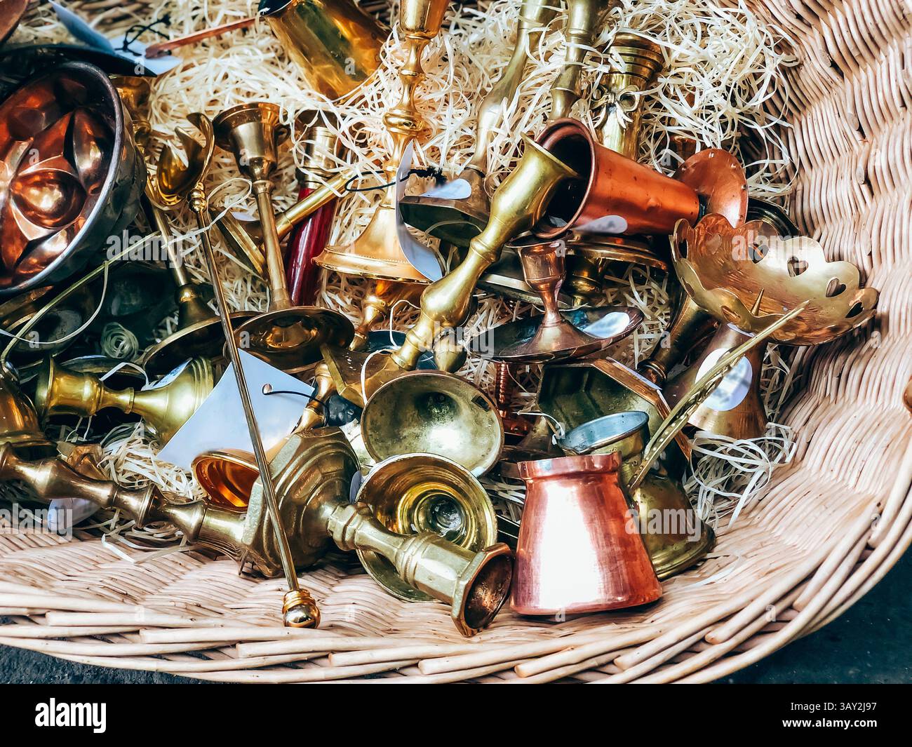Antique brass and copper musical instruments in wicker basket, detailed ...