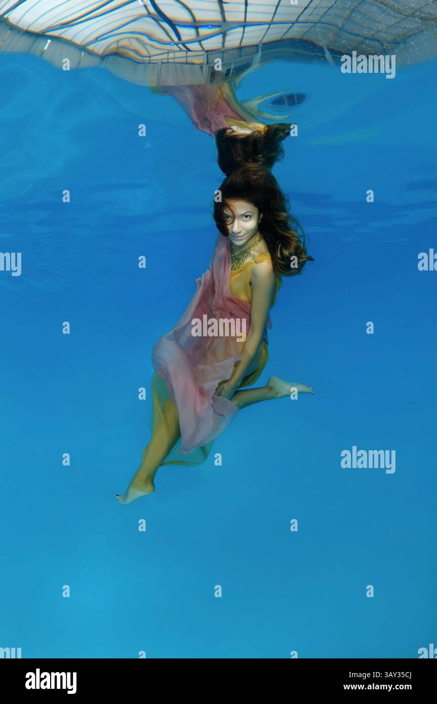 October 15, 2014 - Odessa, pool, Ukraine - Young beautiful woman with long hair in a bright dress under water, underwater fashion in the pool, Odessa, Ukraine (Credit Image: © Andrey Nekrasov/ZUMA Wire/ZUMAPRESS.com) Stock Photo