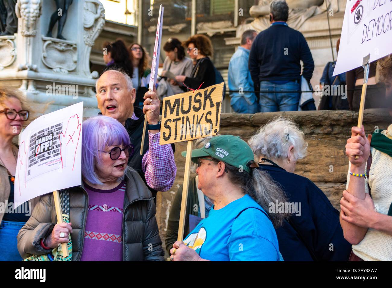 'Hands Off!' protest at Piazza della Signoria, Florence, opposing Trump and Musk’s DOGE policies, defending democracy and public services. Stock Photo