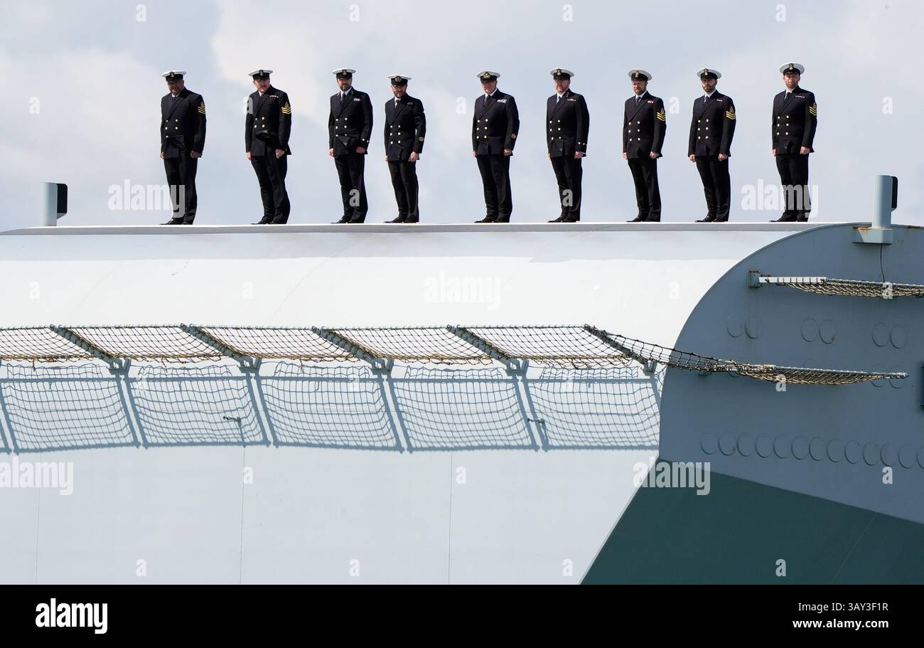 Royal Navy personnel stand on the ski ramp of the Royal Navy aircraft ...