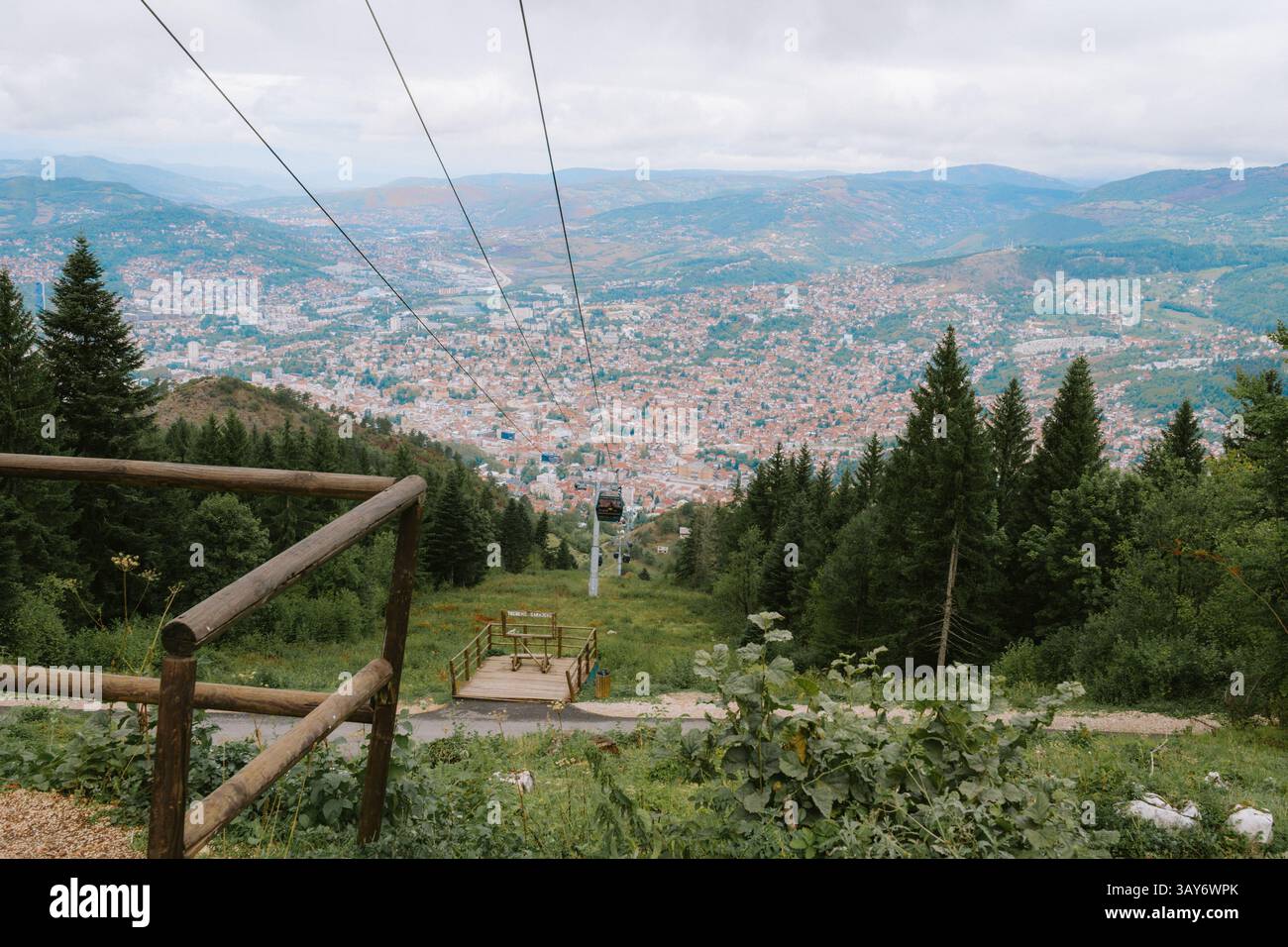 A panoramic view of Sarajevo from Trebević Mountain, framed by forested ...