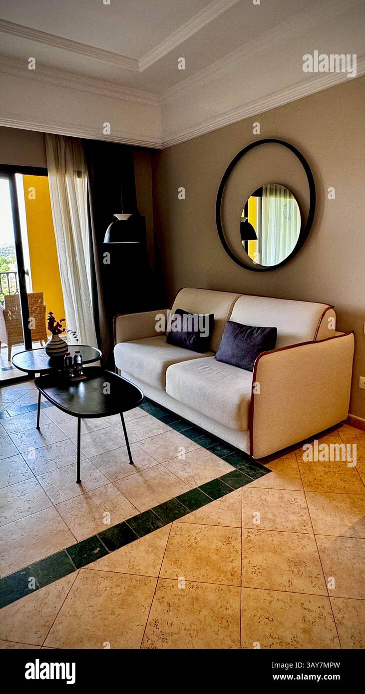 This beautiful image showcases a modern hotel room designed with an elegant and cozy aesthetic. The space features minimalist furniture, including a p - Smartphone Captured Stock Image