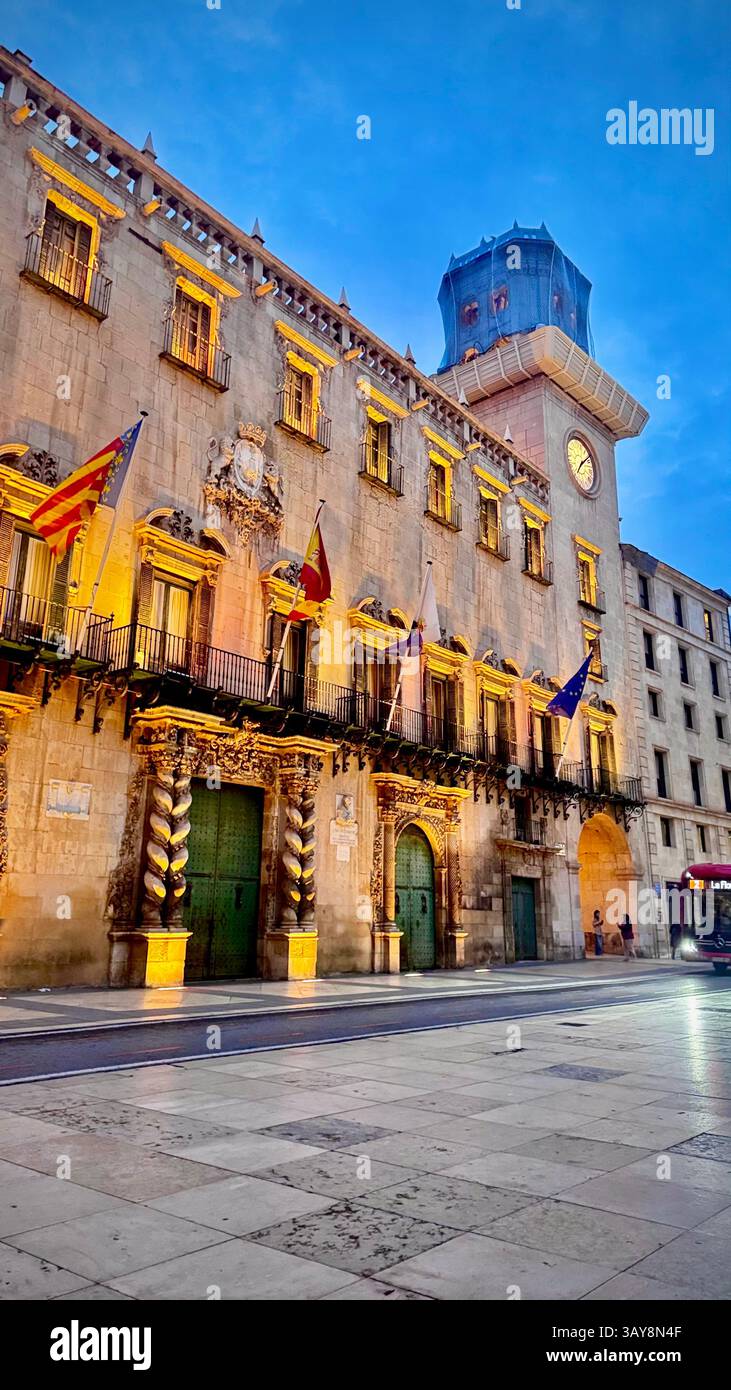 An ornate town hall building beautifully lit during the blue hour in a historic Mediterranean city. The baroque exterior with twisted columns, grand d - Smartphone Captured Stock Image