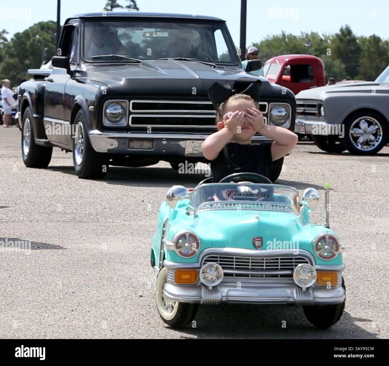 October 2, 2016 - Gulfport, MS, USA - Murtie Marie Parker, 2, of Gulfport, Miss. rides blind as her father, Justin, operates her remote-control classic car on Sunday, Oct. 2, 2016 at Hardy Court in Gulfport on the first day of Cruisin' The Coast. Cruisin' The Coast, an eight-day celebration of classic cars, is celebrating its 20th anniversary this year, with more than 6,000 cars pre-registered. (Credit Image: © John Fitzhugh/TNS via ZUMA Wire) Stock Photo