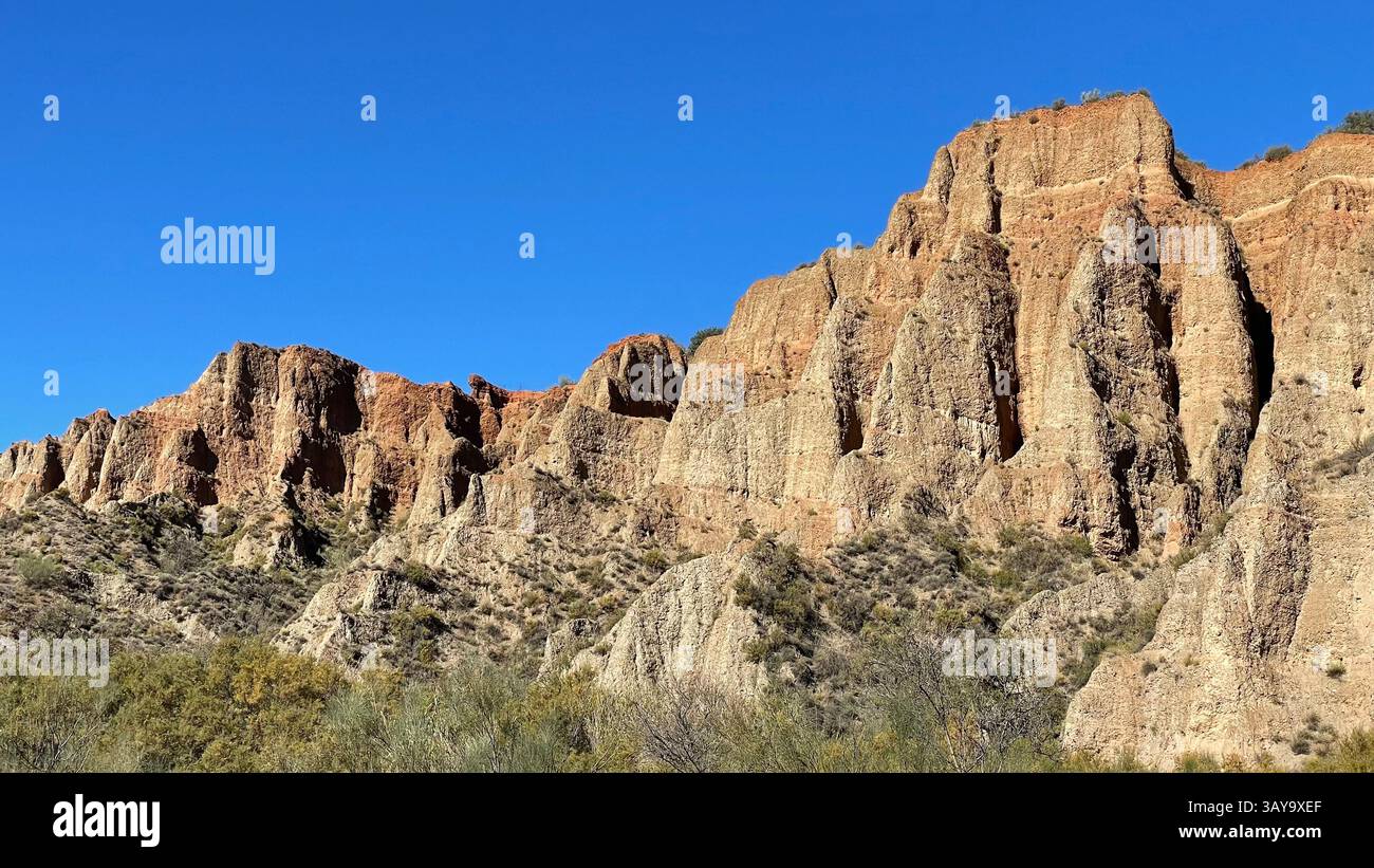 Steep sided eroded cliffs in Andalucía, Spain, against a blue sky. - Smartphone Captured Stock Image