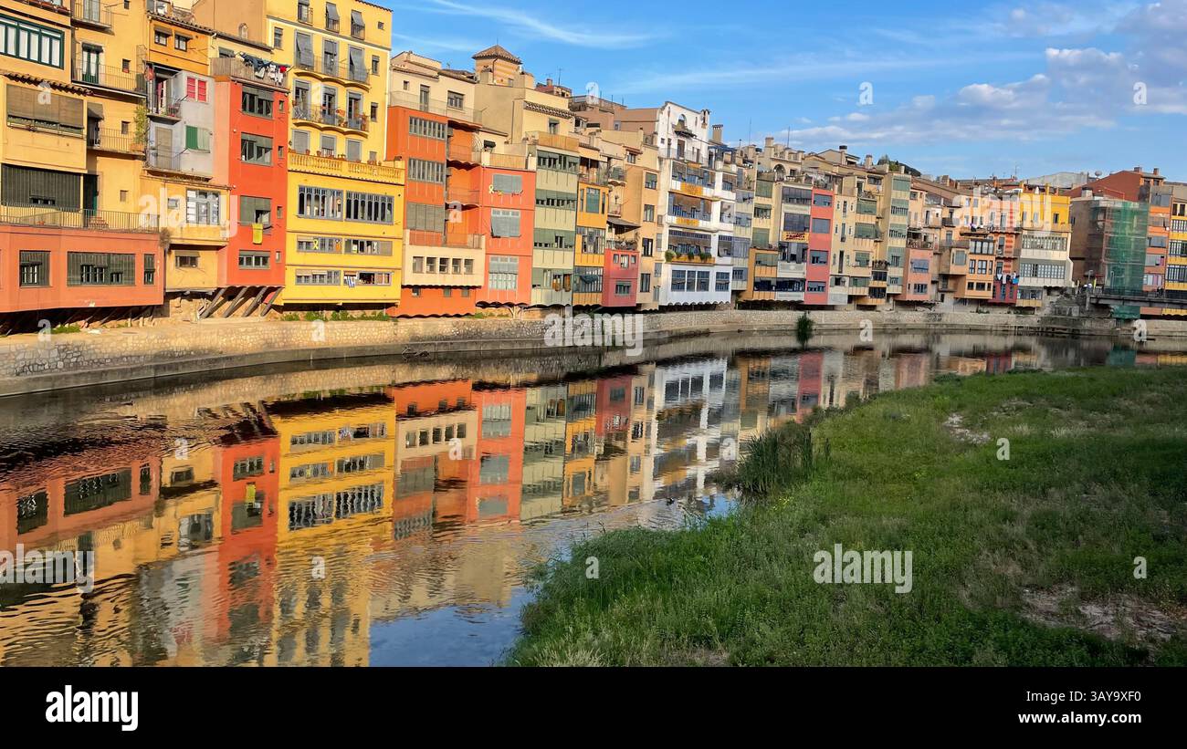 Waterfront scene along the River Onyar in Girona, Catalonia, Spain with reflections on the water. - Smartphone Captured Stock Image