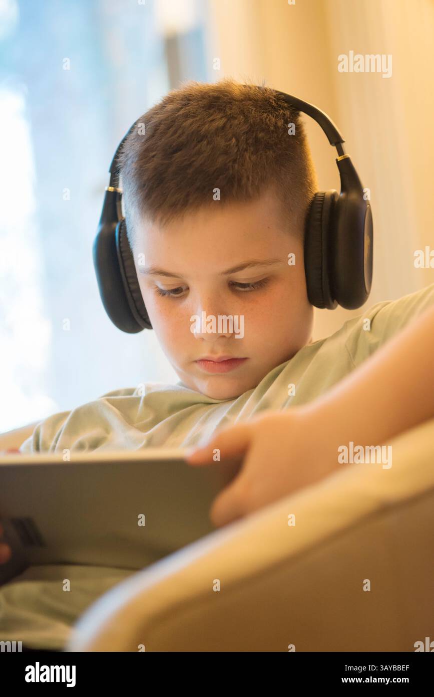 Boy in Headphones Using Digital Tablet Stock Photo