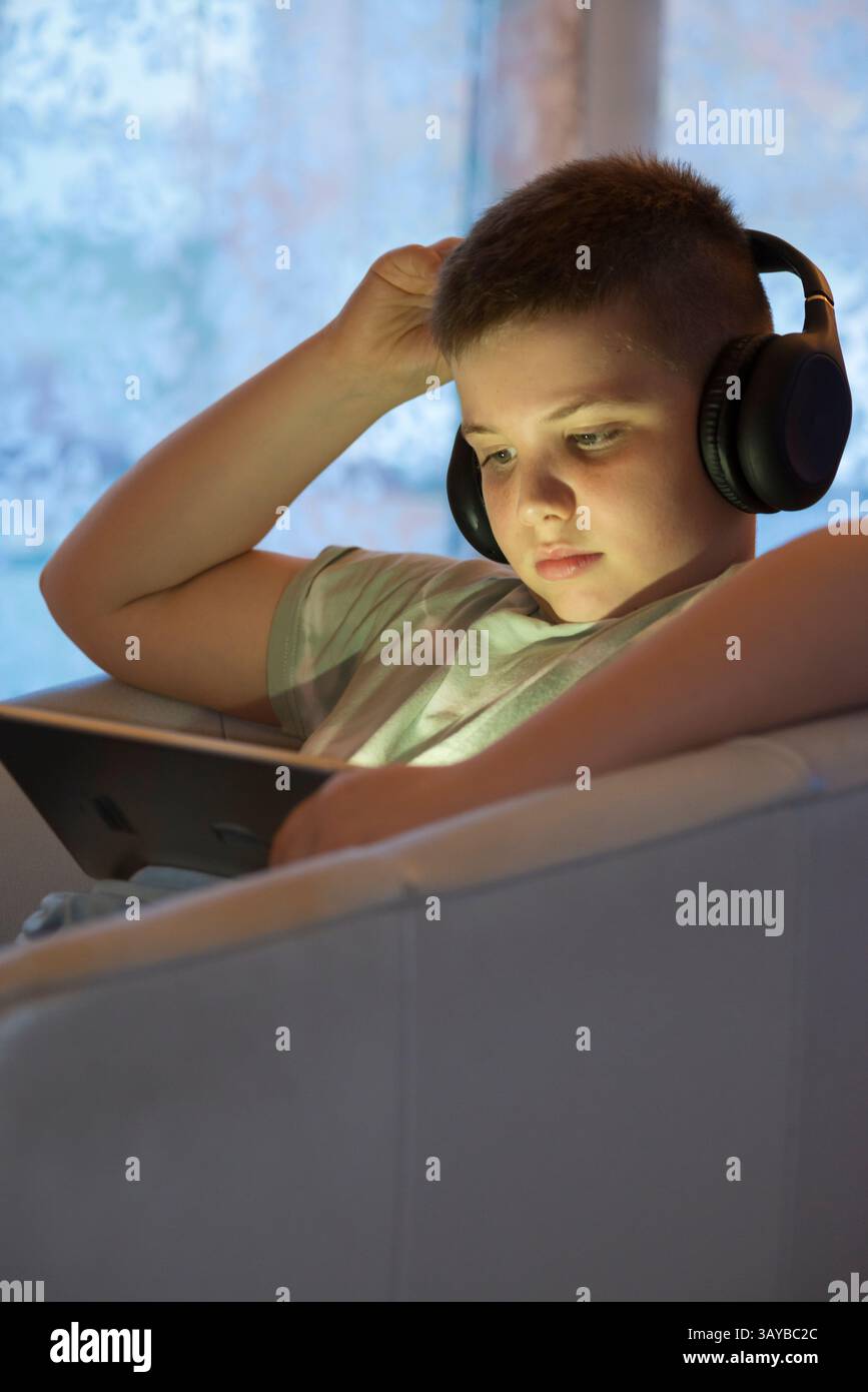 Boy in Headphones Using Digital Tablet Stock Photo