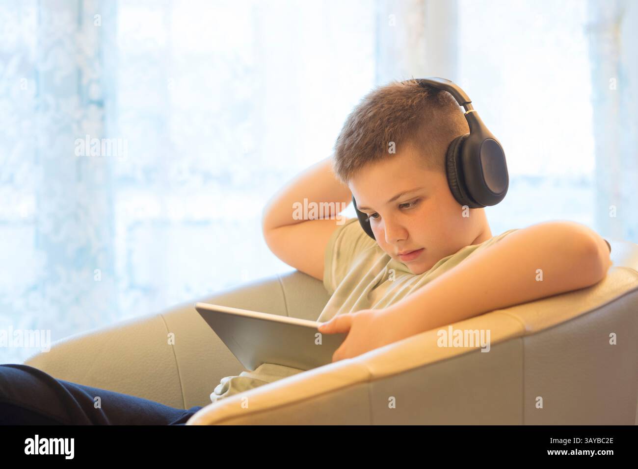 Boy in Headphones Using Digital Tablet Stock Photo