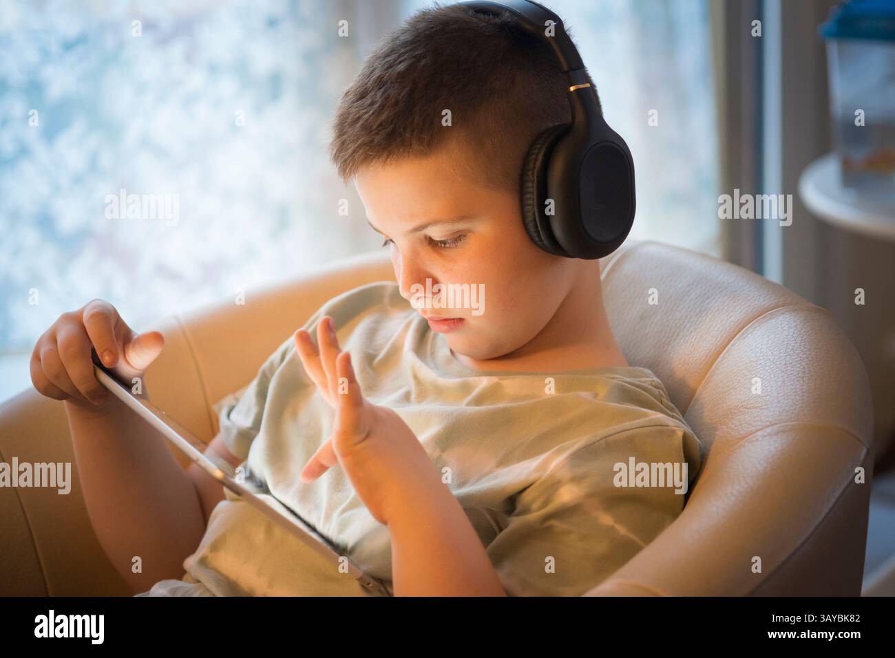 Boy in Headphones Using Digital Tablet Stock Photo