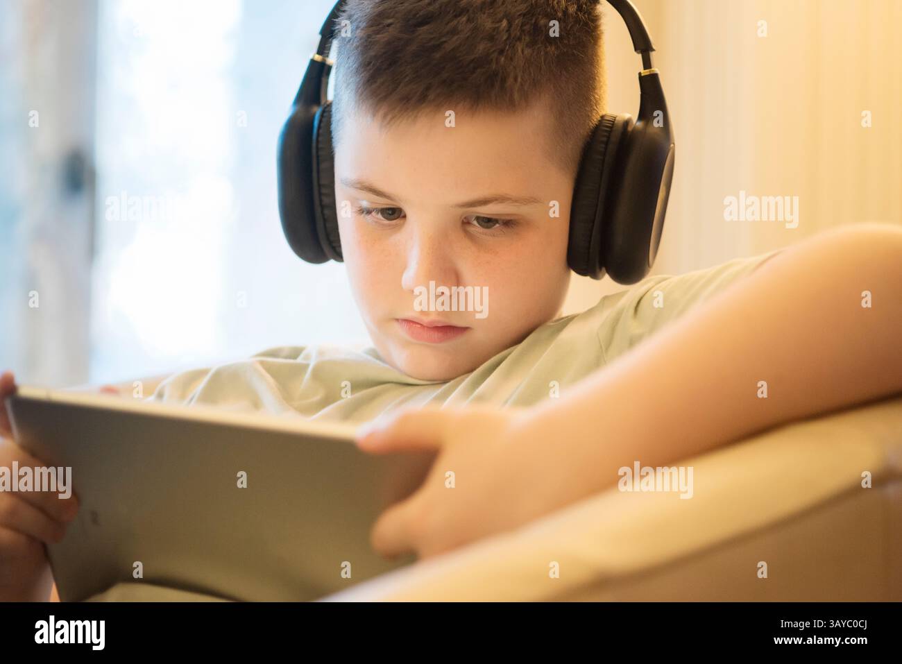Boy in Headphones Using Digital Tablet Stock Photo