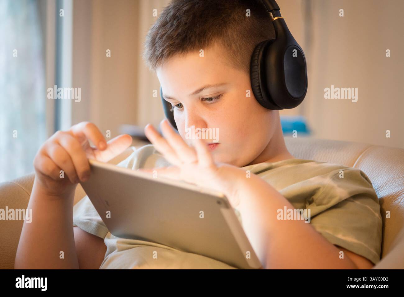 Boy in Headphones Using Digital Tablet Stock Photo
