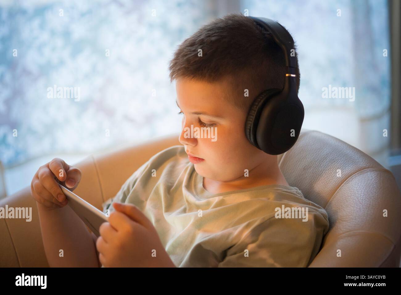 Boy in Headphones Using Digital Tablet Stock Photo