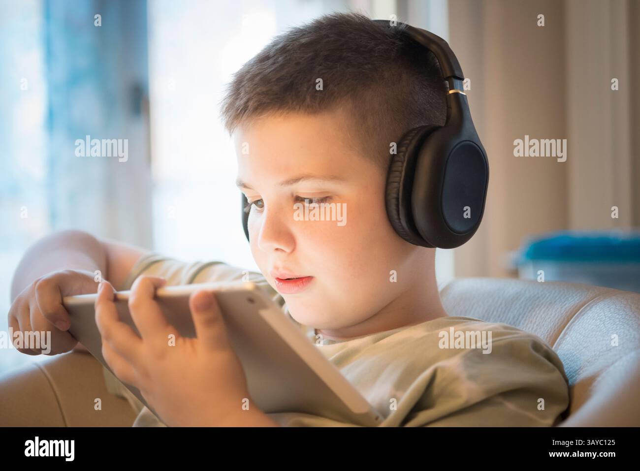 Boy in Headphones Using Digital Tablet Stock Photo