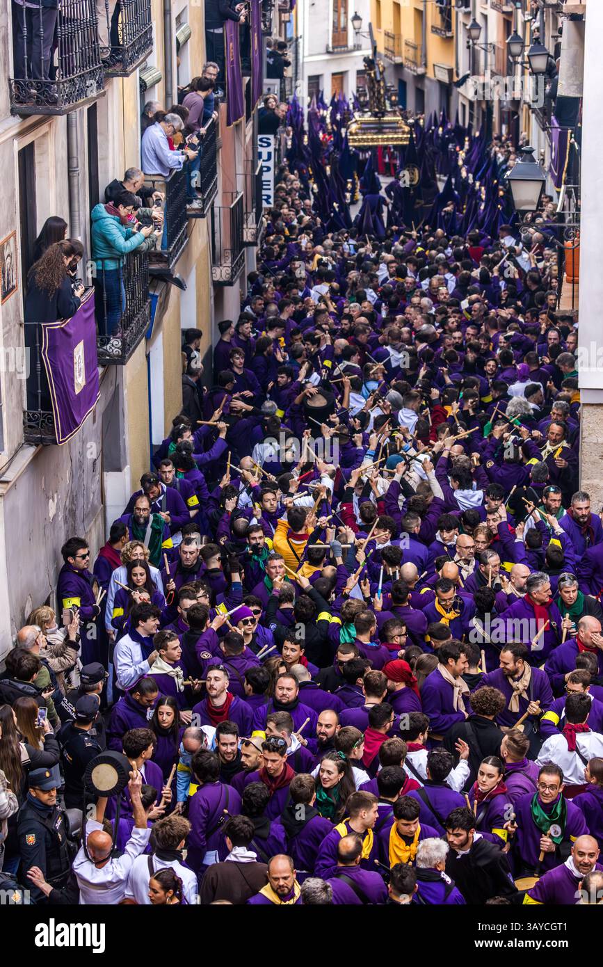 Turbas de Cuenca in purple robes make a deafening noise with their drums (tambores) and trumpets (clarines) at the head of the Camino del Calvario procession, which passes through Cuenca on Good Friday. Plaza Mayor, Cuenca, Castilla-La Mancha, Spain Stock Photo