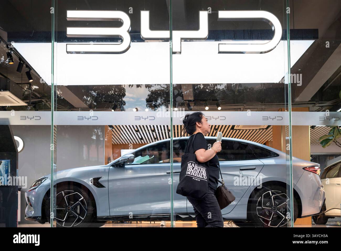 A pedestrian walks past the Chinese automaker BYD official authorized ...