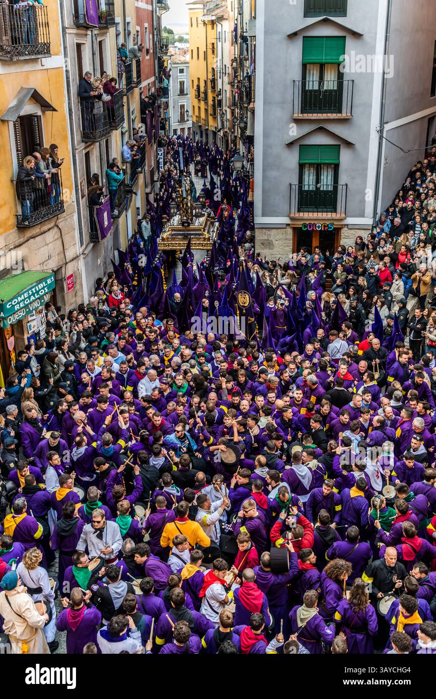 Turbas de Cuenca in purple robes make a deafening noise with their drums (tambores) and trumpets (clarines) at the head of the Camino del Calvario procession, which passes through Cuenca on Good Friday. Calle del Fuero, Cuenca, Castilla-La Mancha, Spain Stock Photo