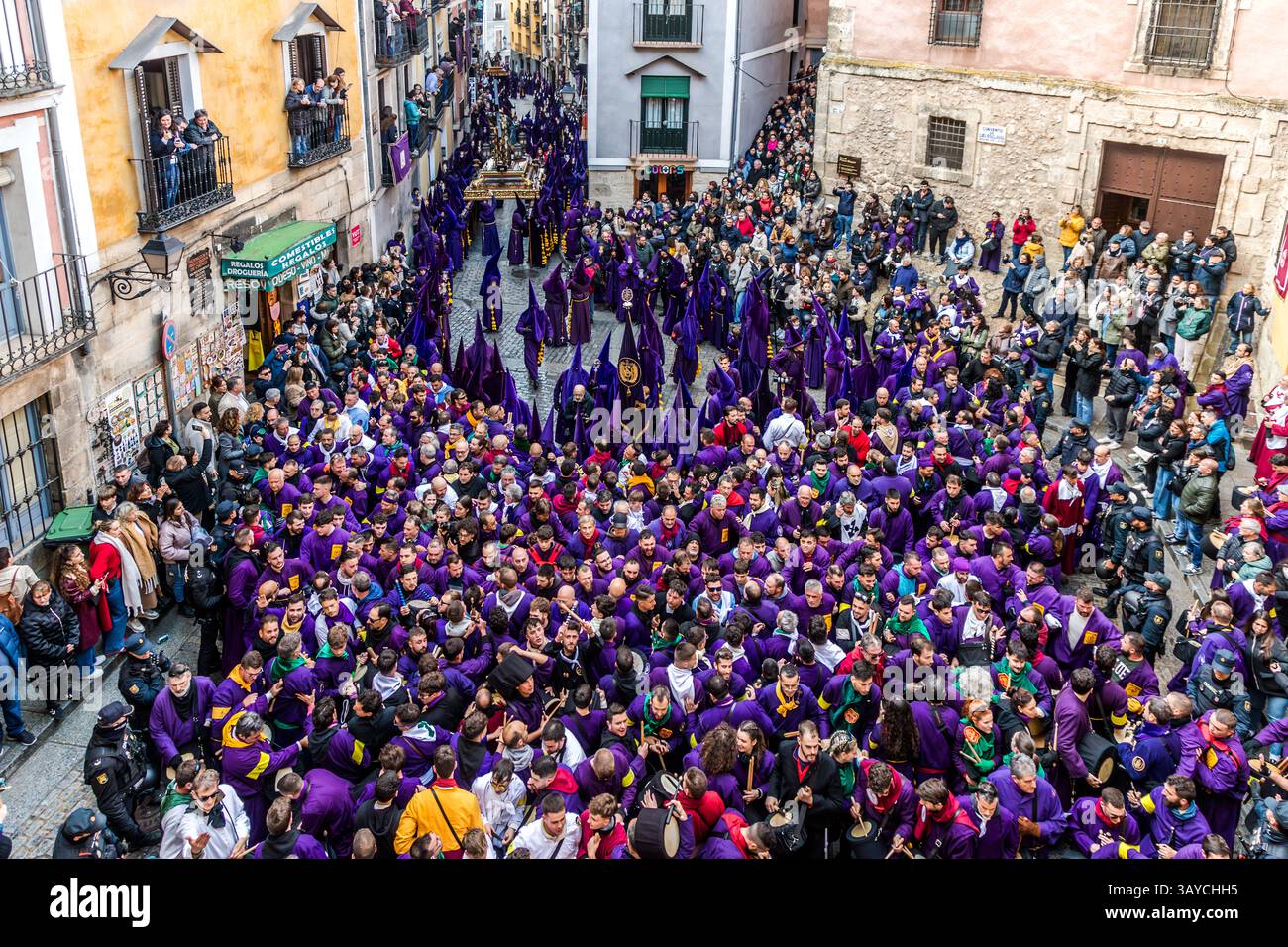 Turbas de Cuenca in purple robes make a deafening noise with their drums (tambores) and trumpets (clarines) at the head of the Camino del Calvario procession, which passes through Cuenca on Good Friday. Calle del Fuero, Cuenca, Castilla-La Mancha, Spain Stock Photo