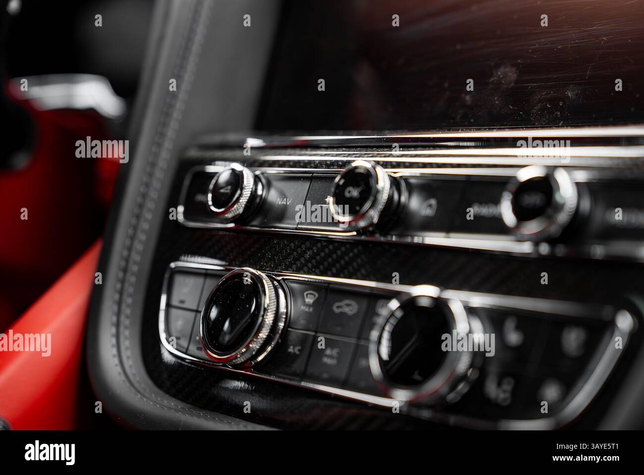 Detailed view of a luxury car's control panel with chrome knobs, carbon ...
