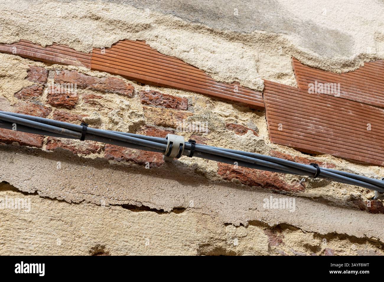 Exposed Brick Wall with Cable Installation Stock Photo