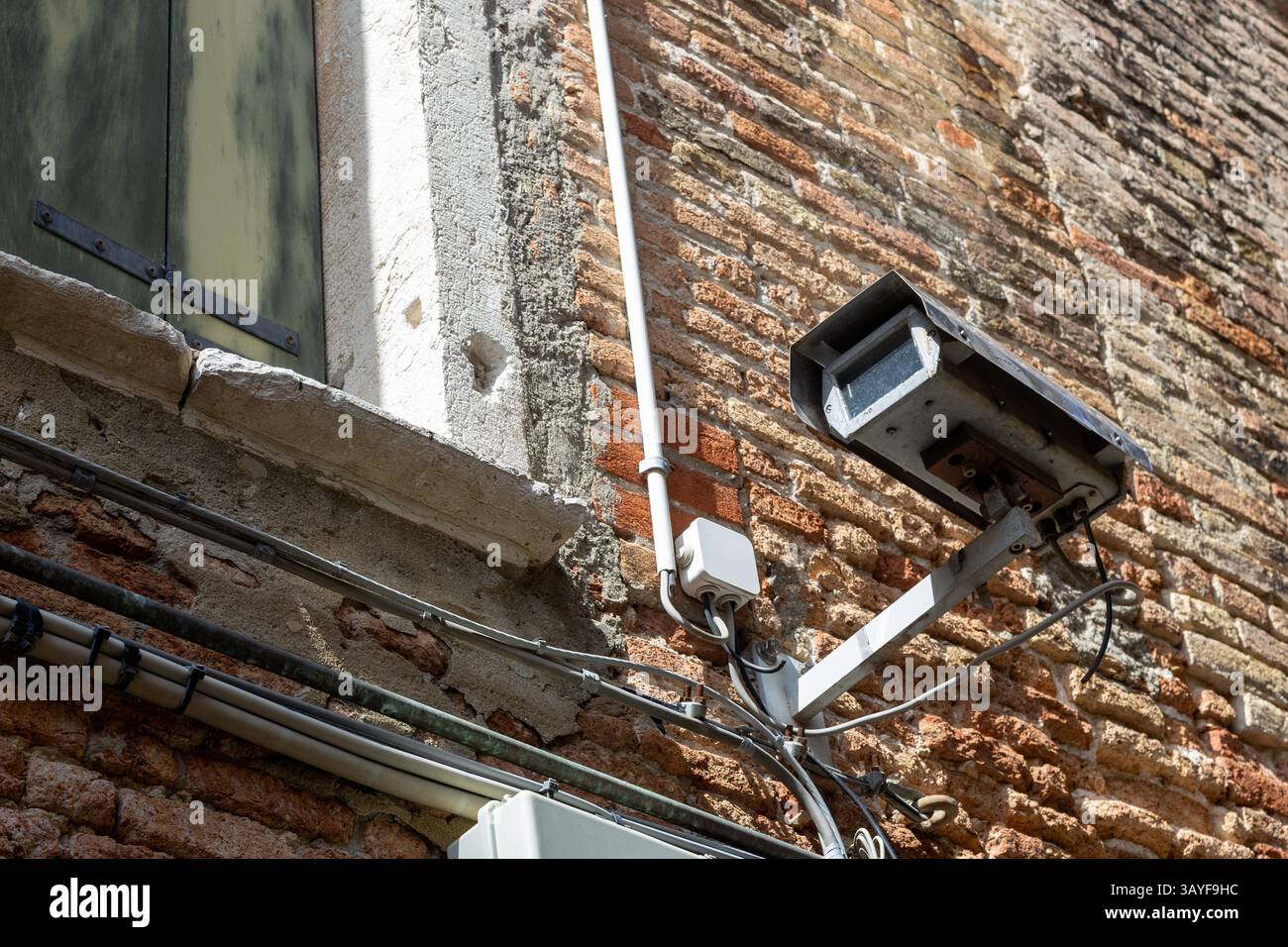 Damaged Old Surveillance Camera on Brick Wall Stock Photo