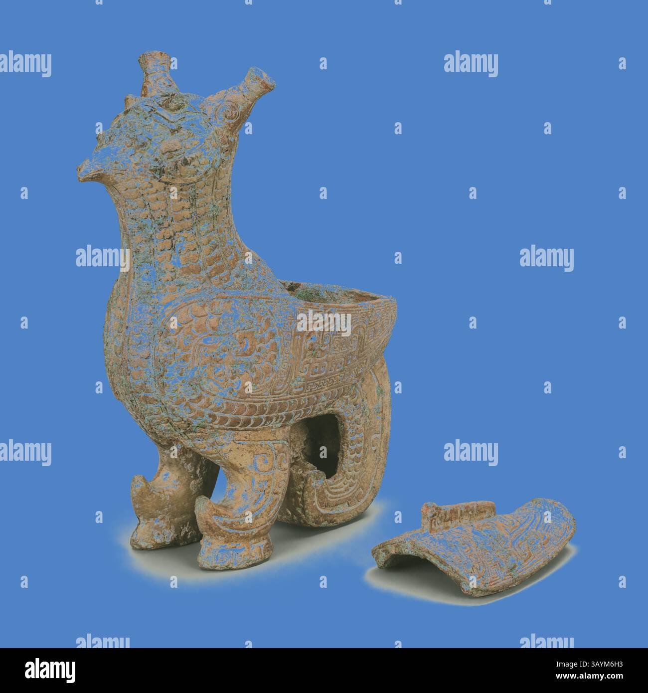An intricately designed vessel shaped like a mythical creature, featuring elaborate carvings and a distinct head with horns. A broken piece lies beside it, showcasing the detailed craftsmanship of the ancient artifact. Bird-Shaped Container (zun), Late Shang dynasty (13th century–1046 B.C.), China, Bronze, H: 6 1/4' × W: 5 1/4' × D: 2 1/4' (15.9cm × 13.3cm × 5.7cm)  Classic art with a modern twist reimagined by Artotop Stock Photo