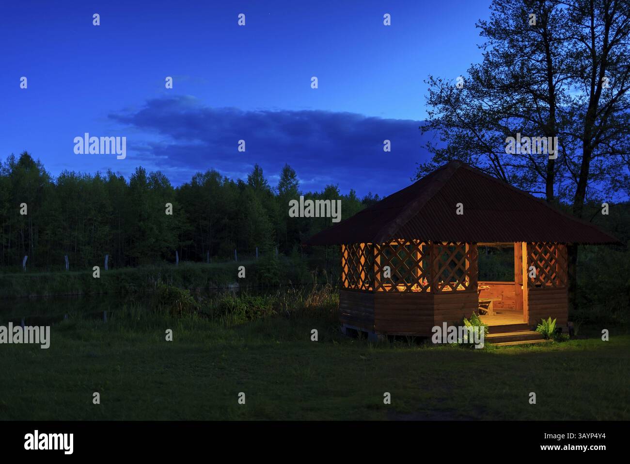 Wooden gazebo on the river bank at night Stock Photo - Alamy