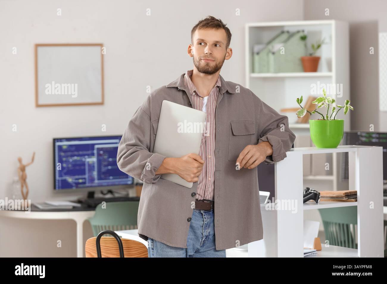 Young bearded programmer with laptop in office Stock Photo