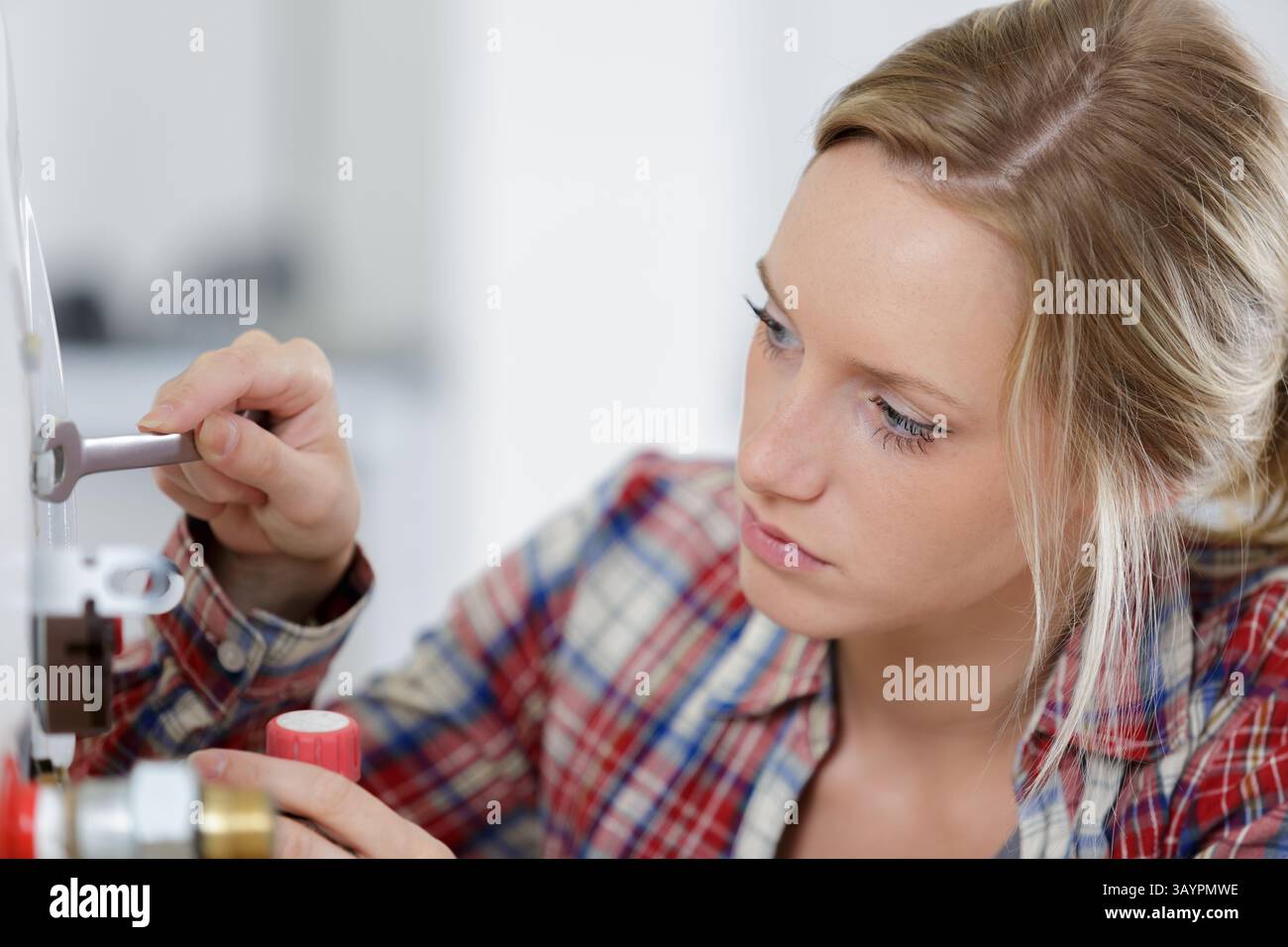 female technician servicing a boiler Stock Photo