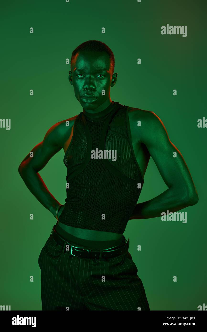 A stylish young man poses confidently, enhanced by striking green ...