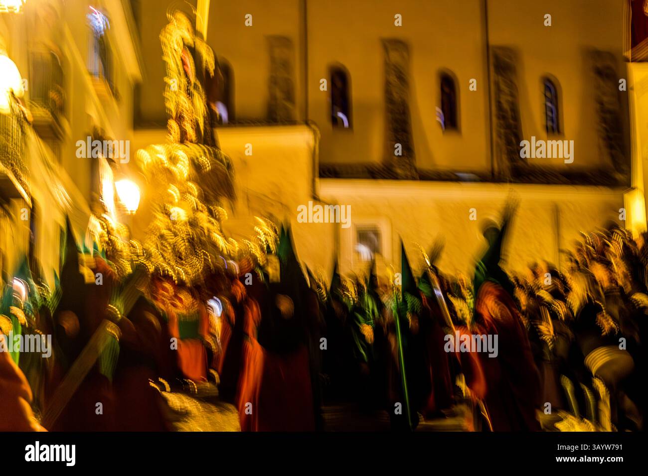 Turbas de Cuenca in purple robes make a deafening noise in front of the Iglesia Parroquial de El Salvador in the middle of the night at the beginning of Good Friday. Plaza Salvador, Cuenca, Castilla-La Mancha, Spain Stock Photo